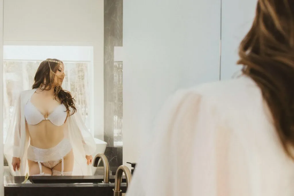 Ava Marie, clad in sophisticated wedding undergarments, is appreciating her own mirror image amid the gentle embrace of soft, natural illumination. Ava Marie Halifax's Elite Independent Companion